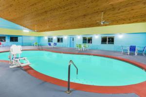 西得梅因Days Inn by Wyndham West Des Moines的一个带蓝色桌椅的大型游泳池