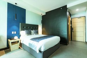 马尼拉Bay Area Suites Manila的一间卧室设有一张大床和蓝色的墙壁