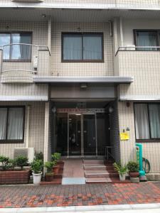 大阪Business Hotel Urbanty Nishikujo的一座有盆栽植物的前门建筑