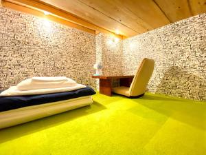 热海马璐亚旅馆的一间卧室配有一张床、一张桌子和一把椅子