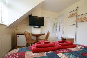 坎伯利Abacus Bed and Breakfast, Blackwater, Camberley, Surrey的一间卧室配有一张床铺,床上铺有红色毯子