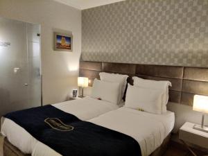 里斯本Seven Dreams Suites的酒店客房设有一张大床和两盏灯。