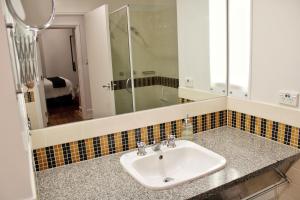 奥克兰Heritage 313 Auckland的一间带水槽和玻璃淋浴的浴室