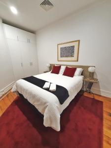 奥克兰Heritage 313 Auckland的一间卧室配有一张红色地毯的大床