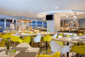 日惹KHAS Malioboro Hotel的用餐室配有桌子和黄色椅子