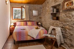 圣胡安-德拉斯阿巴德萨斯La Batllia的一间卧室配有一张床和一张桌子及一本书