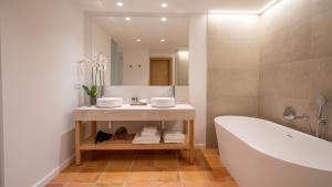 安德莱奇港芒港水疗酒店的带浴缸、水槽和镜子的浴室