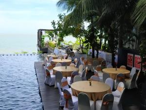 巴厘巴板Golden Tulip Balikpapan Hotel & Suites的水边的一排桌椅