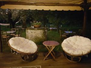 塞拉韦扎Antico Uliveto的帐篷下配有2把白色椅子和1张桌子