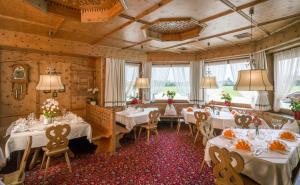 齐勒谷地施特拉斯Hotel Cafe-Zillertal的一间设有白色桌椅和窗户的用餐室