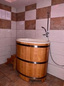 KłobuckNocowanie Restauracja Wenecka的浴室设有带淋浴的木制浴缸。