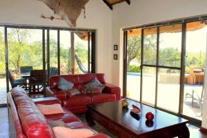 帕拉博鲁瓦Bushvilla Umoja Kruger的客厅配有红色的沙发和桌子