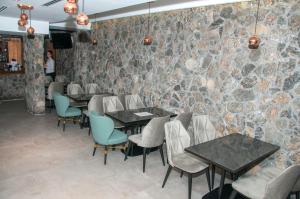 布德瓦明星酒店的一间带桌椅和石墙的餐厅