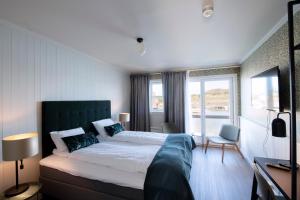 MosterøyUtstein Kloster Hotell的一间卧室设有一张大床和一个大窗户