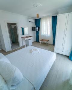 塞利米耶Green Boutique Selimiye的卧室配有一张白色大床和一张书桌