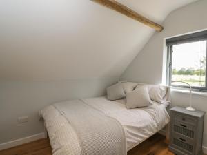威特尼Kingfisher, 2 The Old Stables的白色的卧室设有床和窗户