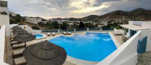 伊奥斯乔拉金色阳光酒店的一个带椅子和遮阳伞的大型游泳池