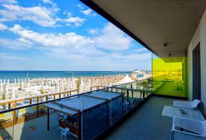 马马亚Riva Mamaia Beach ApartHotel的阳台享有海滩美景,配有遮阳伞