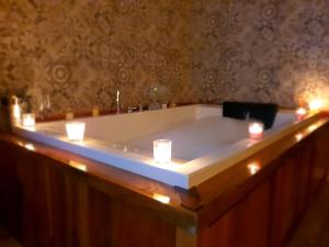 San Miguel de las DueñasHotel rural Finca Vivaldi Nature & Spa的浴缸内有蜡烛和灯光