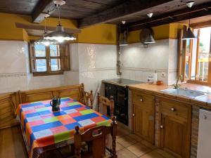 Los Espejos de la ReinaCasa Rural La Costurera的厨房配有一张带五颜六色桌布的桌子