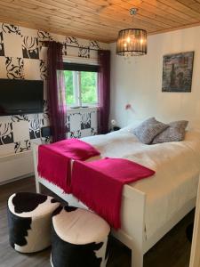 Hjartdal诺布彭约纳特酒店的一间卧室配有一张床铺,床上铺有粉色毯子