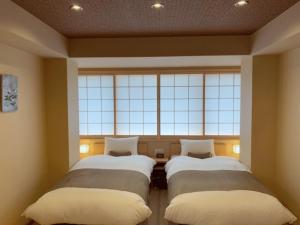 京都Rinn Kitagomon的带大窗户的客房内的两张床