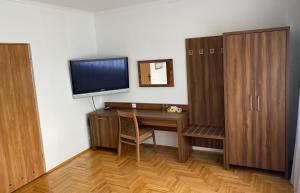 Bolesław玛吉酒店的客房设有书桌、电视和木制橱柜。