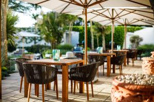 圣布雷拉德大西洋酒店 的一个带桌椅和遮阳伞的户外庭院。