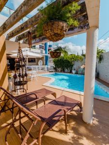 若昂佩索阿Pousada Tropical Bessa的一个带椅子的庭院和一个游泳池