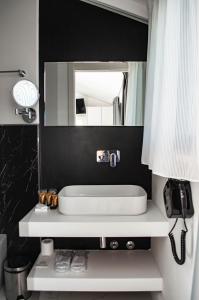 拉戈堡Hotel Boutique Castiglione del Lago的浴室设有白色水槽和镜子
