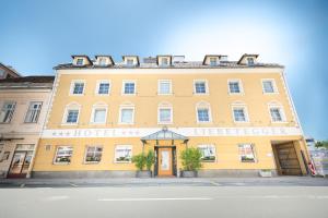 克拉根福Hotel Liebetegger-Klagenfurt的一条大黄楼,坐在街道边