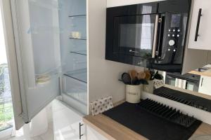 圣布里厄Gare - Les Champs - 1 SDB privative - parking gratuit的厨房配有微波炉和冰箱。