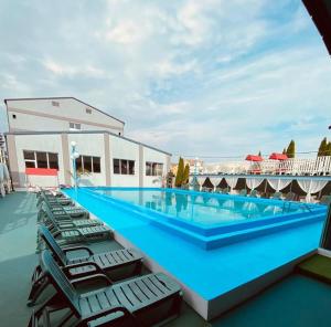 特尔古穆列什黑色勋爵酒店的一座大楼顶部的大型游泳池,配有躺椅