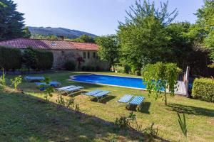 Santa Cristina de Cobres拉腊什乡村民宿的一个带长椅和房子的游泳池的庭院