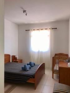 圣港Cantinho Solpraia的一间卧室配有一张带蓝色枕头的床。
