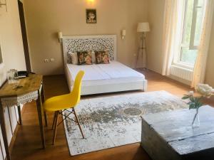 卡尔洛沃诗特利卡洛夫酒店的一间卧室配有一张床、一张桌子和一张黄椅