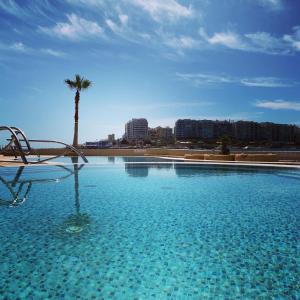 圣朱利安斯卡瓦列里艺术酒店的一个棕榈树背景的大型游泳池