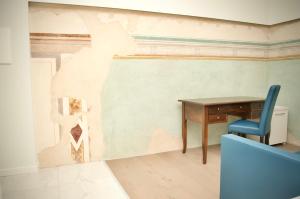 拉戈堡Hotel Boutique Castiglione del Lago的墙上的房间里一张桌子和一把椅子