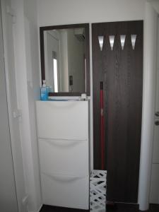 克尔克Apartments Mia Krk的客房设有镜子和白色冰箱。