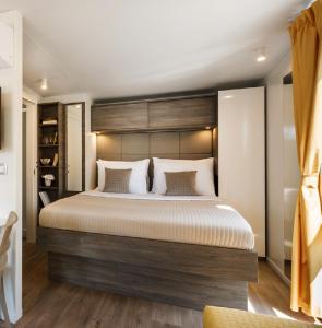 班约勒Victoria Mobilehome in Padova Premium Camping Resort的一间卧室配有一张大床和木制床头板