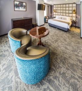 拉巴斯丽兹公寓酒店的酒店客房配有一张床、两把椅子和一张桌子