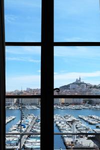 马赛Hotel Belle-Vue Vieux-Port的从带船只的海港窗口欣赏美景