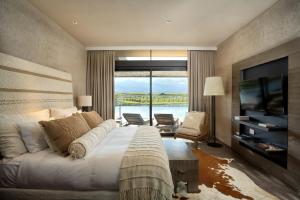 Los SaucesThe Vines Resort & Spa的一间卧室设有一张大床和一个大窗户