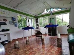 菲兰迪亚Hotel Campestre El Refugio de Balsora的一间设有两张蓝色桌子的房间,还有一些窗户