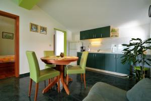 耶泽拉House Klarin的厨房配有木桌和绿色椅子
