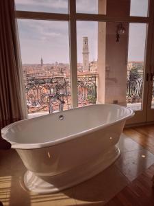 维罗纳Relais Colle San Pietro的窗户客房内的白色浴缸
