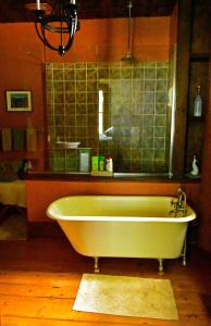马洪贝渔夫之女住宿加早餐旅馆的浴室配有浴缸及镜子