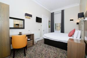 格拉斯哥大使酒店的酒店客房配有一张床、一张桌子和一把椅子。