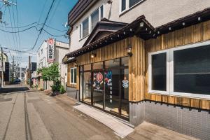 札幌Yamahana Onsen Tonden Japanese Inn的城市街道上建筑物前面的商店