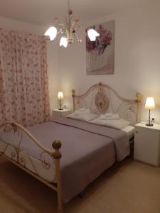 法扎纳克劳迪亚公寓的一间卧室配有一张带两盏灯的大型白色床。